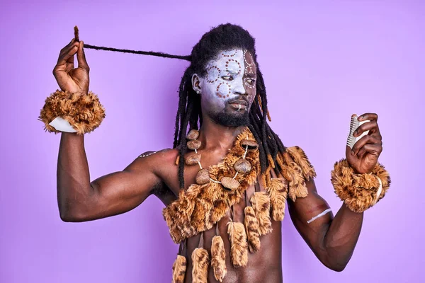 Grappige sjamaan tribal man proberen te begrijpen hoe moderne kammen te gebruiken voor haar — Stockfoto