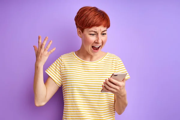 Femme caucasienne en colère avec les cheveux courts roux crier à l'écran de téléphone mobile — Photo