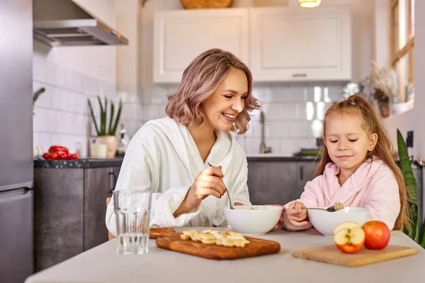 Hübsche Mädchen genießen Mahlzeit zum Frühstück mit Mama — Stockfoto