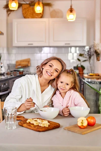 Hübsche Mädchen genießen Mahlzeit zum Frühstück mit Mama — Stockfoto