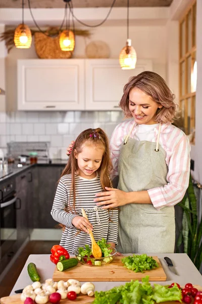 Young woman teach daughter to mix salad — Stock Photo, Image
