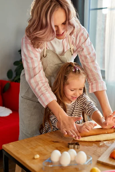 Mère montrant fille préscolaire comment dérouler la pâte pour tarte ou biscuits — Photo