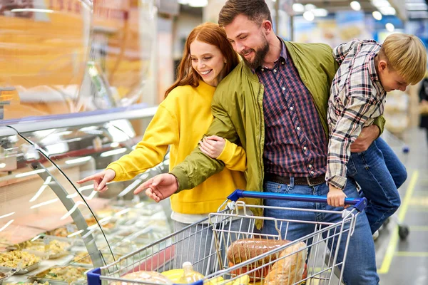 Vrolijk paar, ouders met rusteloze zoon in supermarkt — Stockfoto