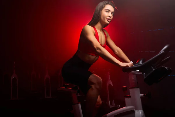 高加索黑发女子自行车手。1.她正在体育馆里锻炼 — 图库照片