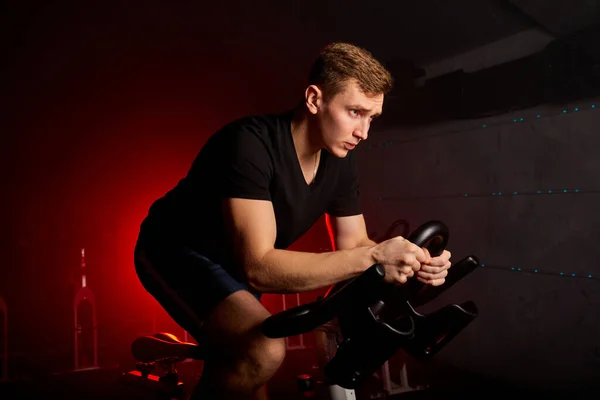 Biciklizés a fitneszklubban. aktív magabiztos férfi edzés a sporteszközökben az edzőteremben — Stock Fotó