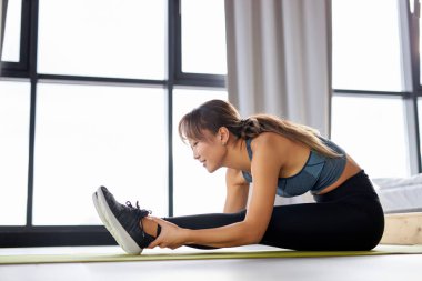 Güzel görünümlü kadın esneme egzersizi evde, kopyalama alanı