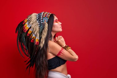 Kafasında tüy olan uzun saçlı şaman kadın.