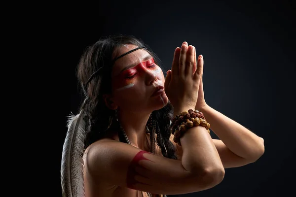 Portret van sjamanistische vrouw met Indiase veer op haar en kleurrijk geschilderde make-up — Stockfoto