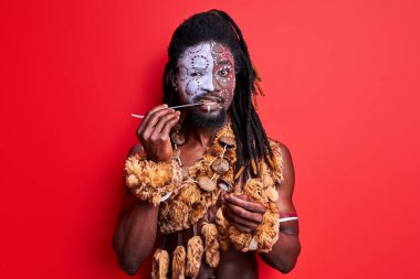 Komik ilkel Afrikalı yerli adam modern çatal bıçak kullanmaya çalışıyor.