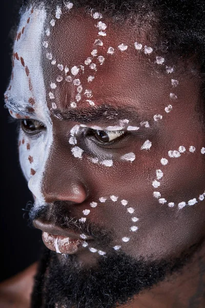 Pensativo homem africano com etnia make-up stand pensando para baixo — Fotografia de Stock