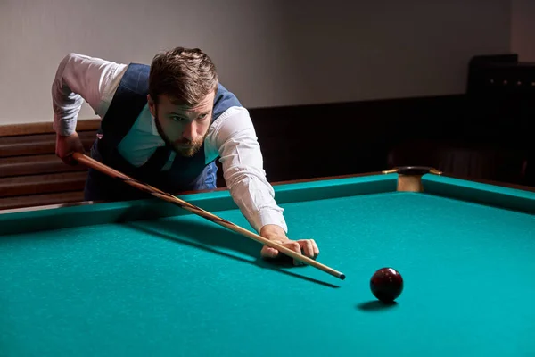 Ung stilig kaukasisk man lutar sig över bordet medan du spelar snooker — Stockfoto