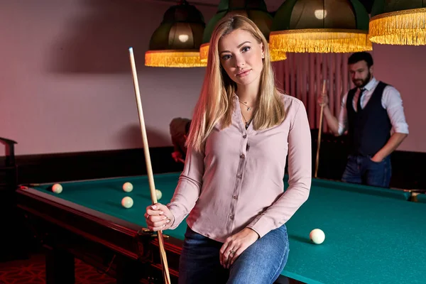 portrait of attractive lady came to play billiards or snooker with friends