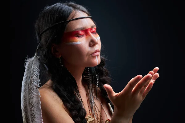 Tenang shamanic perempuan dengan bulu India mengenakan dan makeup berwarna-warni — Stok Foto