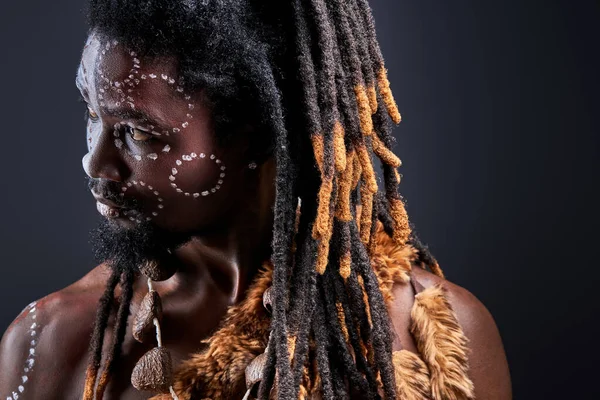 Nachdenklicher Stamm mit Dreadlocks, die auf die Seite schauen — Stockfoto