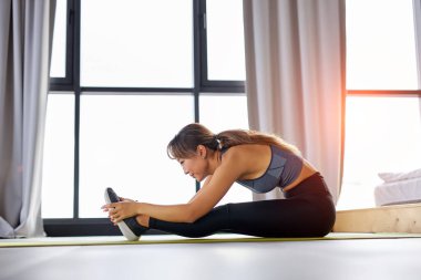 Güzel görünümlü kadın esneme egzersizi evde, kopyalama alanı