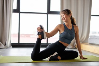 Kadın bacaklarını açıyor, evde antrenman yapıyor.