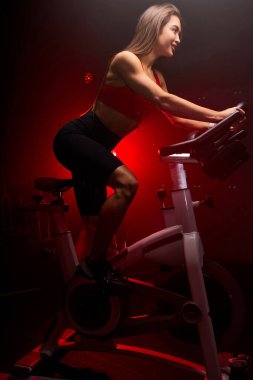 pozitif esmer kadın bisikletçi. Spor salonunda egzersiz yapıyor.