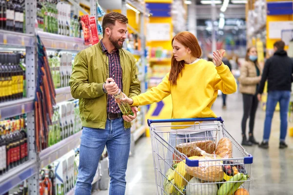 Boze roodharige vrouw ruzie met man die wil alcohol fles te kopen — Stockfoto