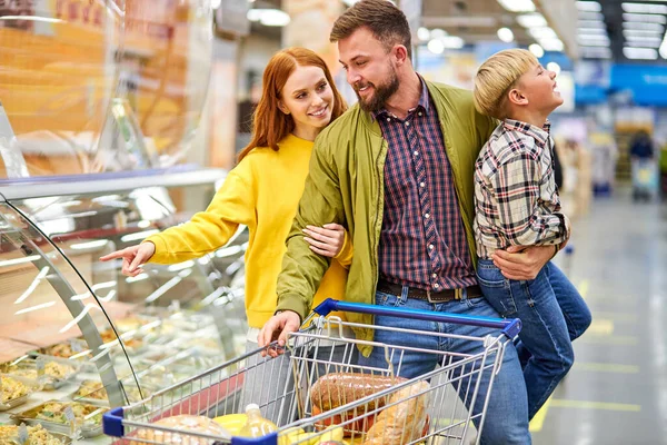 Vrolijk paar, ouders met rusteloze zoon in supermarkt — Stockfoto