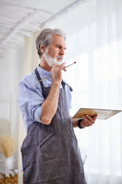 Professional artist man is drawing on easel canvas — Stock Photo, Image