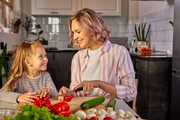 Hermosa madre adulta e hija van a preparar ensalada fresca juntos —  Fotos de Stock