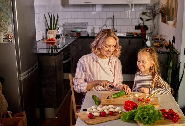 Beautiful adult mother and daughter are going to prepare fresh salad together — Stock Photo, Image