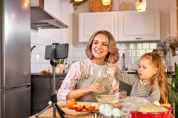 Ευτυχισμένη οικογένεια στην κουζίνα. food blogger μητέρα και κόρη ετοιμάζουν τη ζύμη — Φωτογραφία Αρχείου