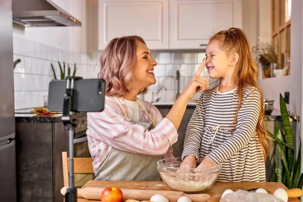 Mãe blogueiro de alimentos registra o processo de cozinhar com a filha na câmera smartphones — Fotografia de Stock