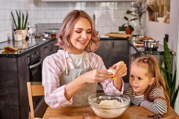Carinhoso mãe caucasiana e pouco adorável filha cozinhar juntos na cozinha — Fotografia de Stock