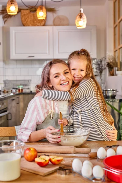 Positiv lächelnde Mutter mit Tochter, die beim Kochen vor der Kamera posiert — Stockfoto