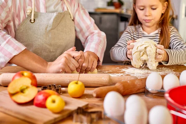 Figlia caucasica aiutare la mamma impastare preparare la pasta in cucina moderna — Foto Stock