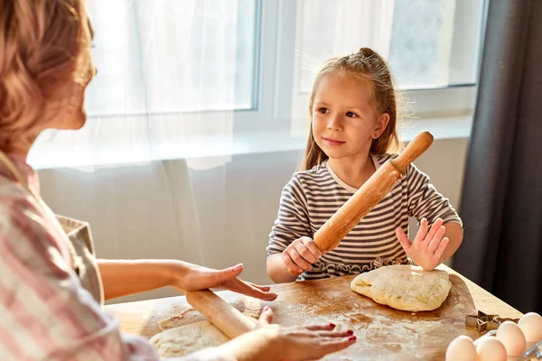 Jeune maman enseigner petite fille faire pâte travail utilisation rouleau broche dans la cuisine — Photo