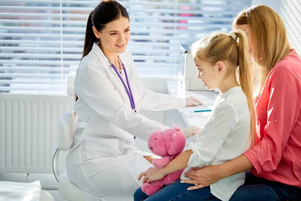 Pediatra mujer bienvenida paciente niño pequeño y su madre en la cita de chequeo médico —  Fotos de Stock