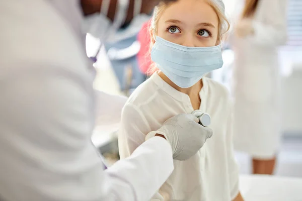 African male doctor checking heartbeat of kid girl —  Fotos de Stock