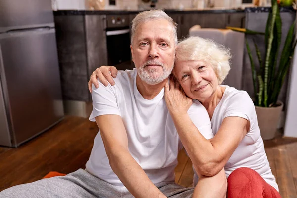 Portrait of beautiful good-looking senior couple having rest on the floor — Stok fotoğraf