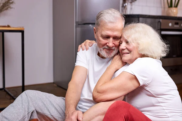 Beautiful senior couple sit having rest on the floor — Stock Photo, Image