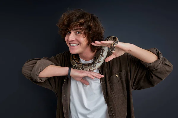 Веселий усміхнений хлопець стоїть сміливий зі змією на нього — стокове фото