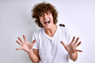 young caucasian man in a white T-shirt with spider on a white background