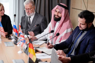 Uluslararası iş adamlarından oluşan bir grup çalışıyor ve iletişim kuruyor.