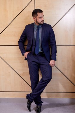 full-length portrait of handsome caucasian bearded businessman in suit posing