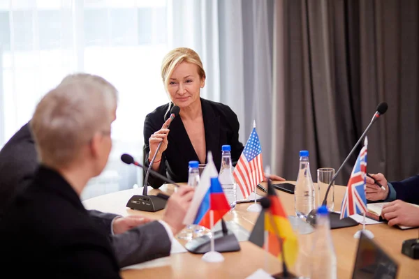 Erwachsene kaukasische Delegierte in Formalbekleidung schaut ins Publikum — Stockfoto