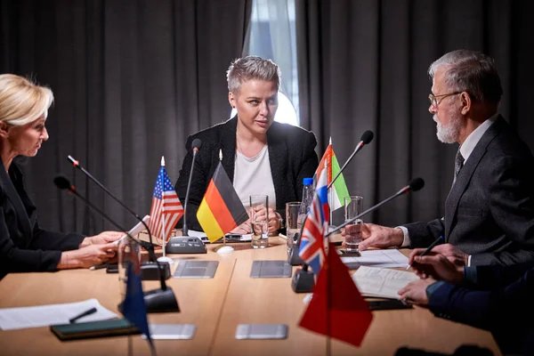 Multi-ethnic business entities gathered together for negotiating meeting lead by businesswoman — Fotografia de Stock