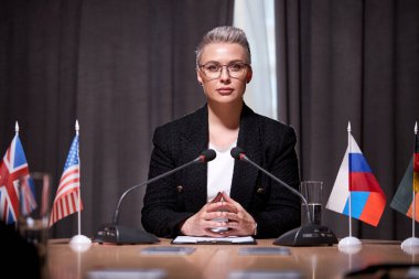 Olgun, kendine güvenen bir kadın mikrofon toplama toplantısına katılır.