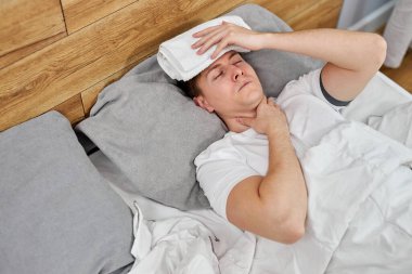 Yüksek sıcaklık kavramı. Genç adam ağır koronavirüs semptomları gösteriyor.