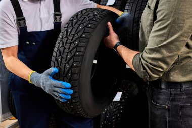 two men looking at auto tire surface
