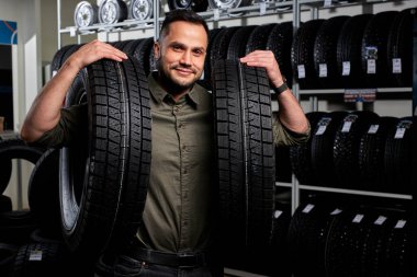 male customer is satisfied with purchase of tyre in automobile repair garage.