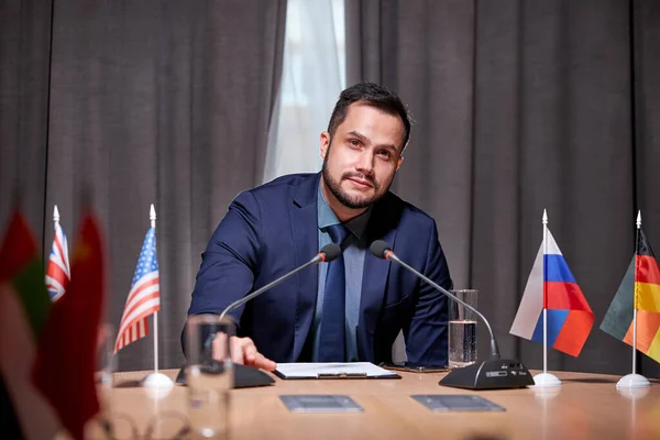 Homem de negócios caucasiano confiante sentar falando no microfone na reunião — Fotografia de Stock