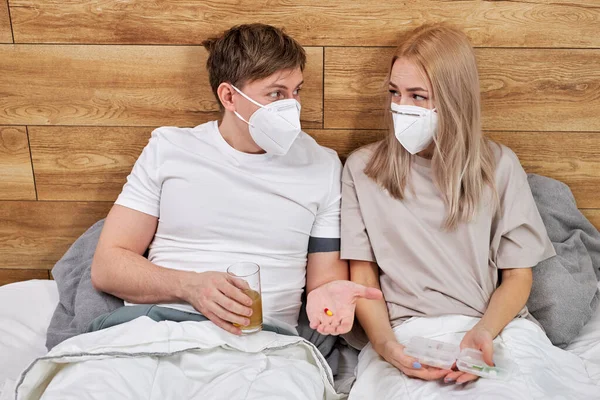 Sick couple at home with coronavirus disease lie on bed together and talk — Stockfoto