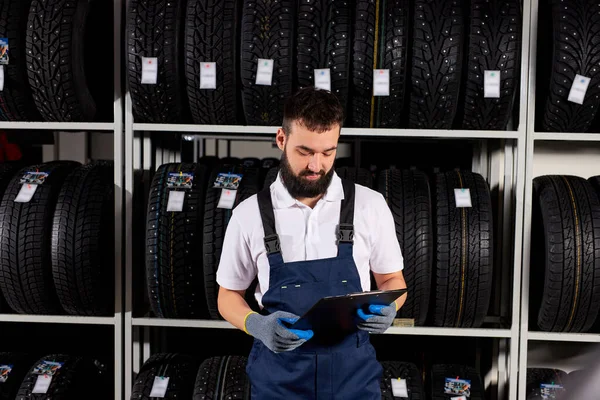 Europäische männliche Mechaniker halten Papiertablette Dokument in den Händen, während die Überprüfung des Sortiments in Auto-Reparatur-Service — Stockfoto