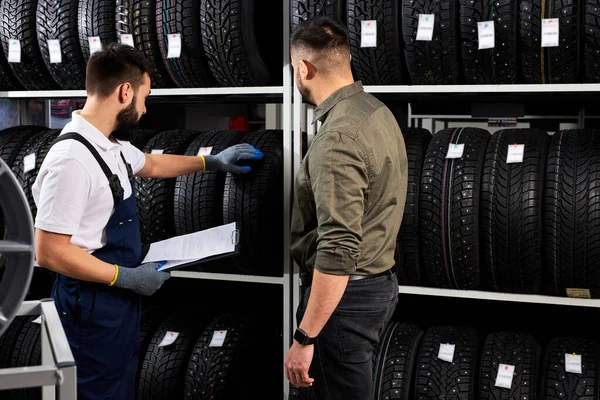 Il venditore offre nuove ruote in gomma, pneumatici, cerchioni per l'auto — Foto Stock